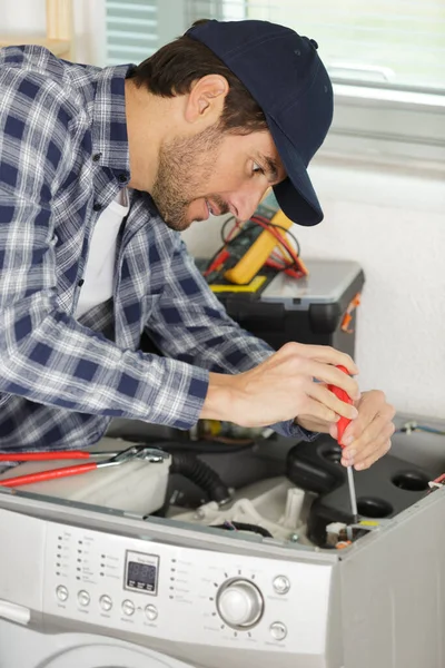 Man Schroeven Een Wasmachine Witte Achtergrond — Stockfoto