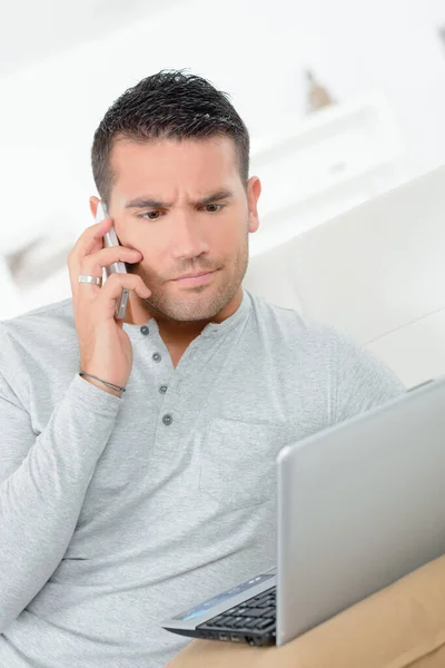 Człowiek Martwi Się Przez Telefon Pomocą Laptopa — Zdjęcie stockowe