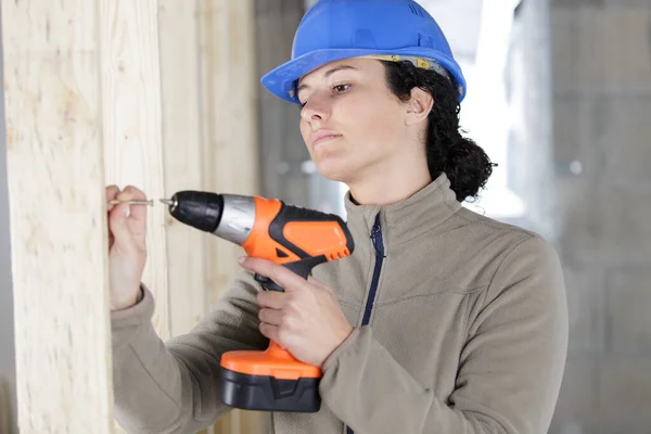 有钻孔机工具钻墙的女建筑工人 — 图库照片