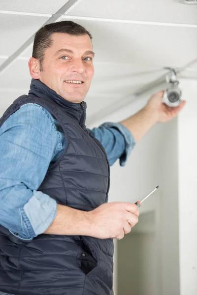 Man Monteert Een Bewakingscamera Aan Het Plafond — Stockfoto