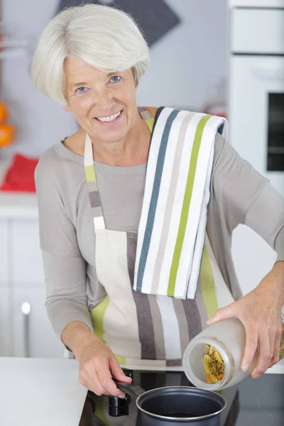 Vrolijke Senior Vrouw Stand Kachel Keuken — Stockfoto