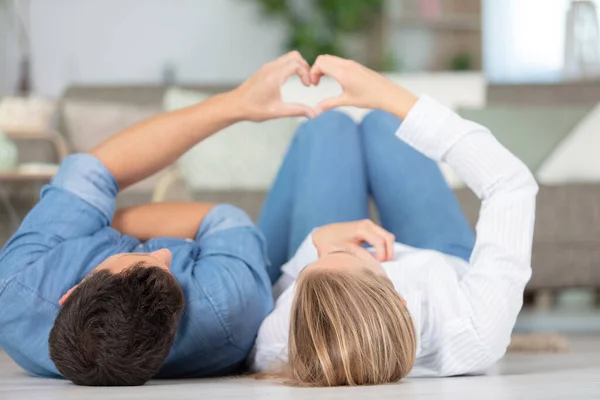 Pareja Tendida Suelo Haciendo Signo Del Corazón Con Las Manos — Foto de Stock