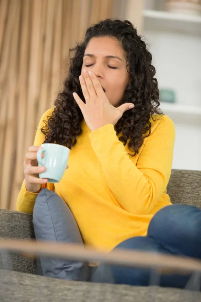 Jovencita Sofá Sosteniendo Una Taza Bostezando — Foto de Stock