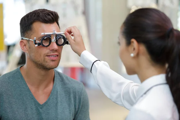 眼科医は目の検査中に別のレンズを試して — ストック写真