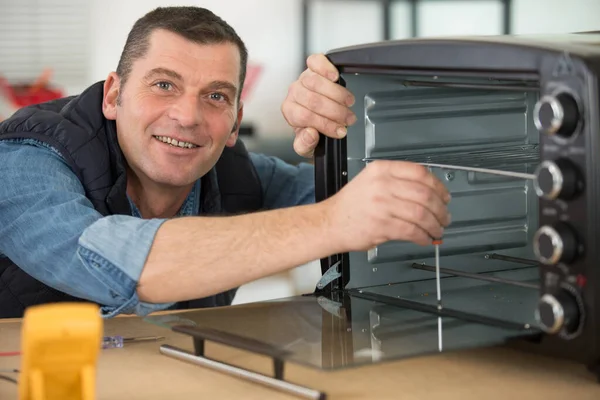 repairman fixing and repairing microwave oven