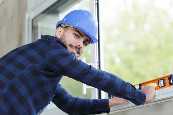 Constructor Joven Que Comprueba Ventana Con Nivel Espíritu —  Fotos de Stock