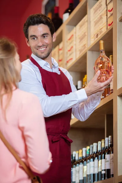 Vendedor Supermercado Ofreciendo Botella Vino Mujer Sonriente — Foto de Stock