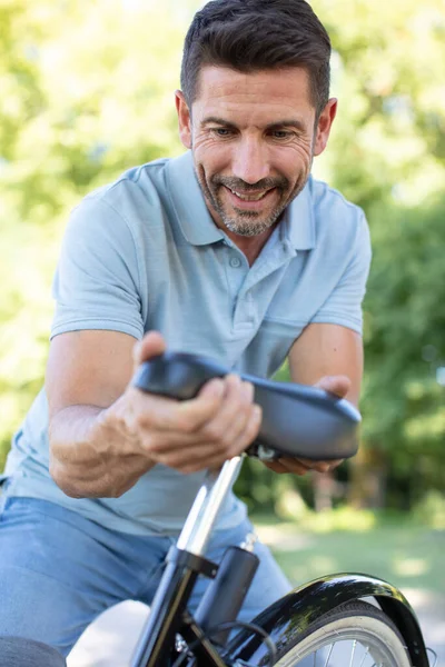 Ciclista Macho Maduro Ajustando Asiento Bicicleta — Foto de Stock