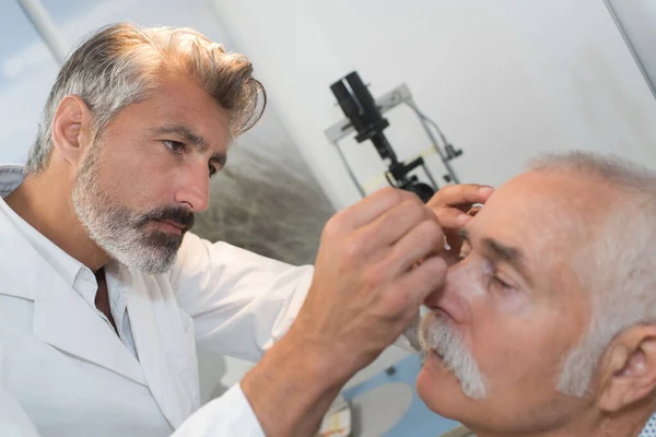 Doctor Putting Drops Senior Mans Eyes — Stock Photo, Image