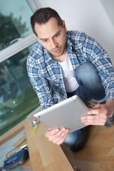 Man Fitting Flooring Looking Digital Tablet Surprise — Stock Photo, Image