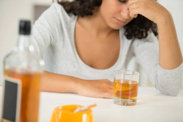 Flaska Med Alkohol Bordet Och Berusad Kvinna Bakgrunden — Stockfoto