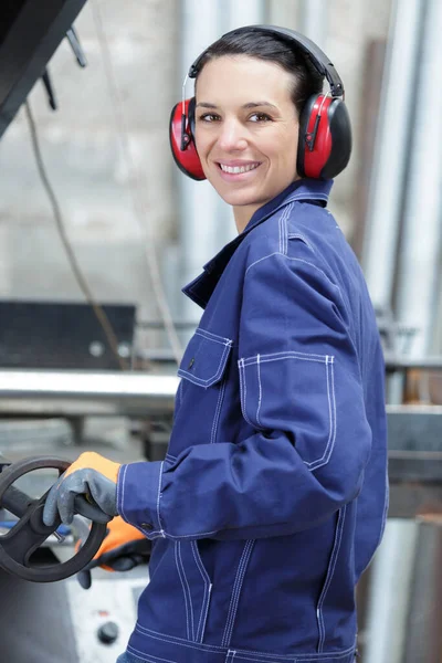 smiling attractive  female carpenter with ear protectors