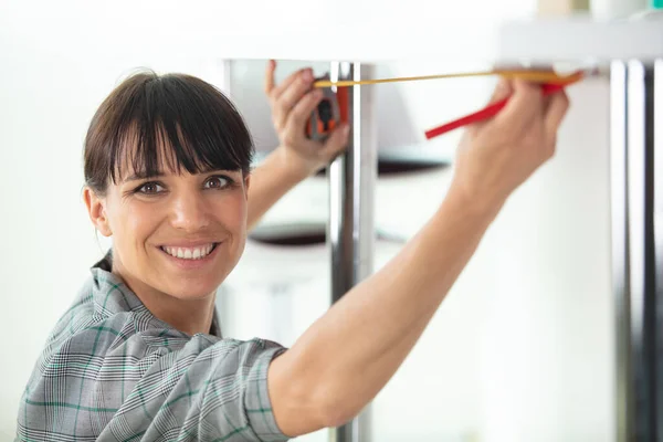 Frau Misst Möbel Mit Maßband — Stockfoto