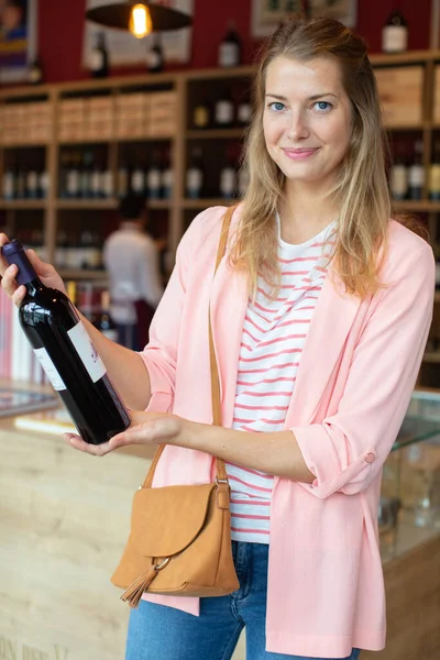 Joven Mujer Está Eligiendo Una Botella Vino — Foto de Stock