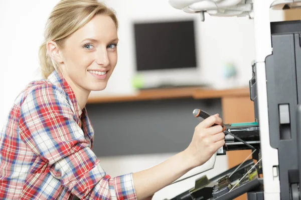 オフィスのプリンターを修理する幸せな女性 — ストック写真