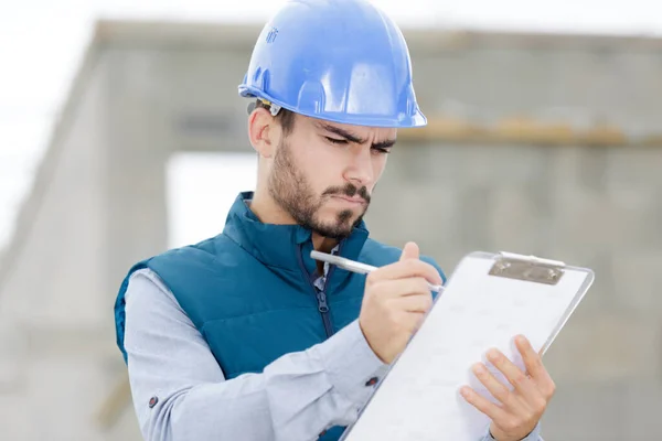 Constructor Masculino Inspeccionando Portapapeles —  Fotos de Stock