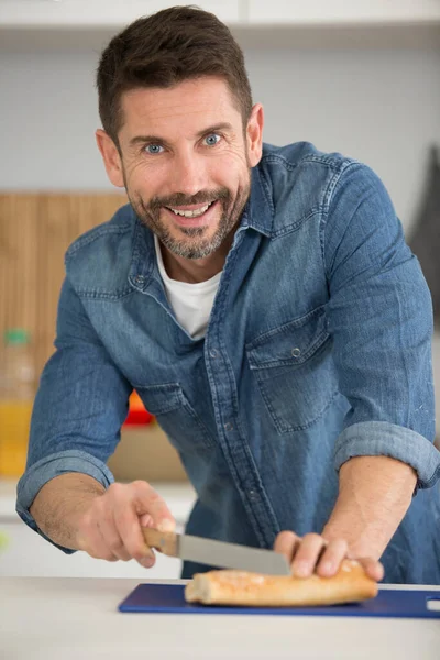 Homem Cortando Fatias Pão Cozinha — Fotografia de Stock