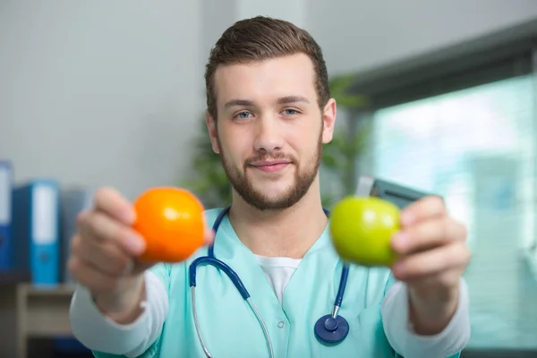 Πορτρέτο Ενός Ευτυχισμένου Αρσενικού Γιατρού Που Δίνει Μήλα — Φωτογραφία Αρχείου