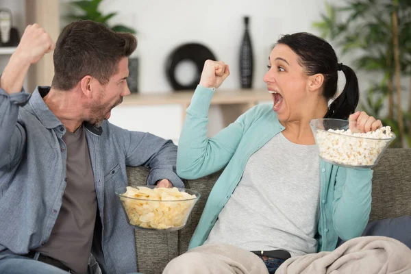 Ζευγάρι Τρώει Ποπ Κορν Μαζί Και Βλέποντας Τηλεόραση Στον Καναπέ — Φωτογραφία Αρχείου