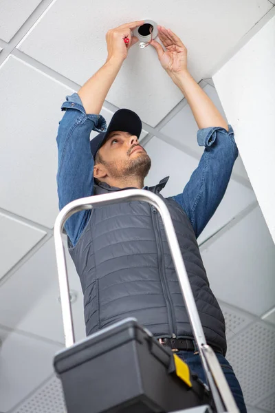 Uomo Piedi Sulla Scala Cambiando Una Lampadina — Foto Stock