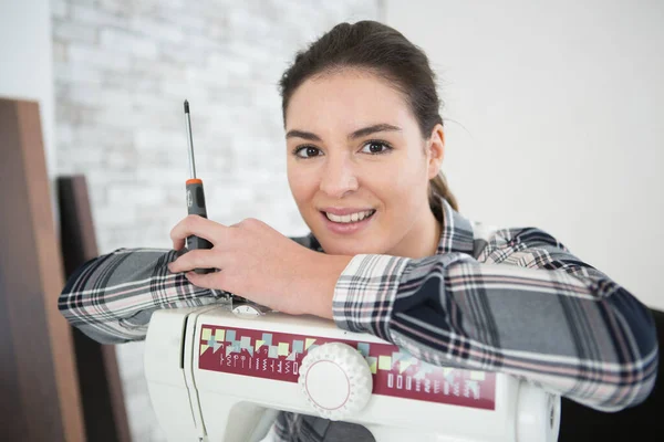 Kvinna Som Håller Skruvmejsel Lutar Sig Mot Symaskin — Stockfoto