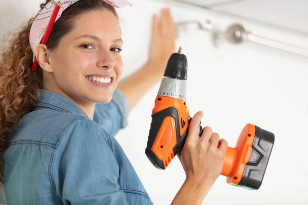 Vrouw Met Draadloos Gereedschap Een Gordijnrail Hangen — Stockfoto