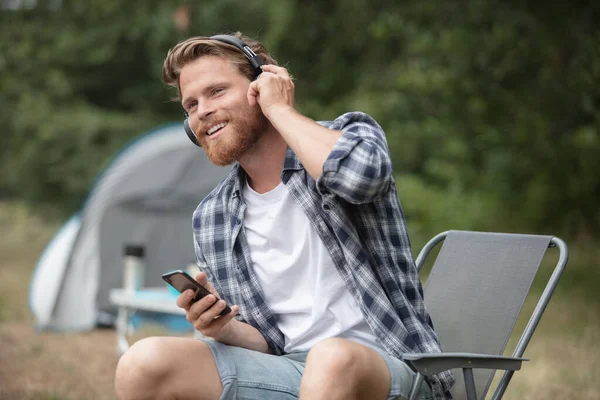 Mężczyzna Kempingu Namiotem Przy Użyciu Telefonu Słuchać Muzyki — Zdjęcie stockowe