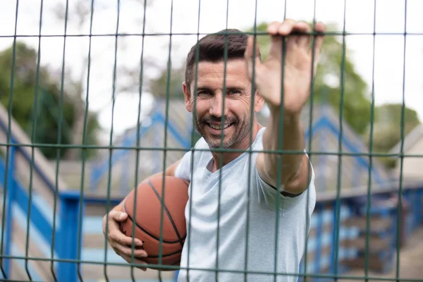 Basketballspieler Lehnt Sich Zaun Und Hält Ball Freien — Stockfoto