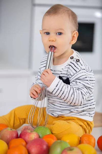 Baby Sat Amongst Fresh Fruit Biting Whisk — Stock Photo, Image