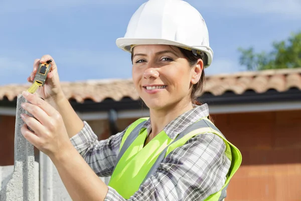 Mooie Vrouw Een Helm Meten Van Een Muur — Stockfoto