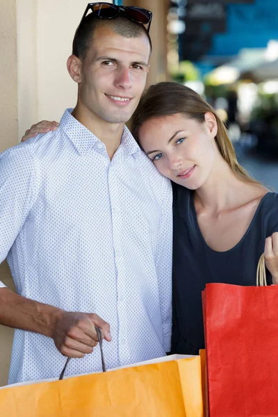 快乐的年轻夫妇抱着购物袋互相拥抱 — 图库照片