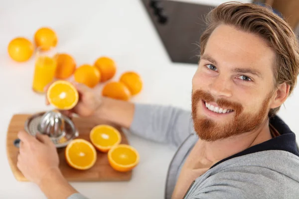 有魅力的年轻人在准备橙汁 — 图库照片