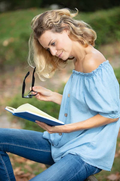 Πλαϊνή Άποψη Της Ευχαριστημένος Γυναίκα Ανάγνωση Του Βιβλίου Στο Πάρκο — Φωτογραφία Αρχείου