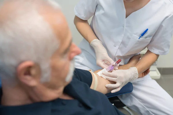Joven Doctora Tomando Muestras Sangre Pacientes Mayores —  Fotos de Stock