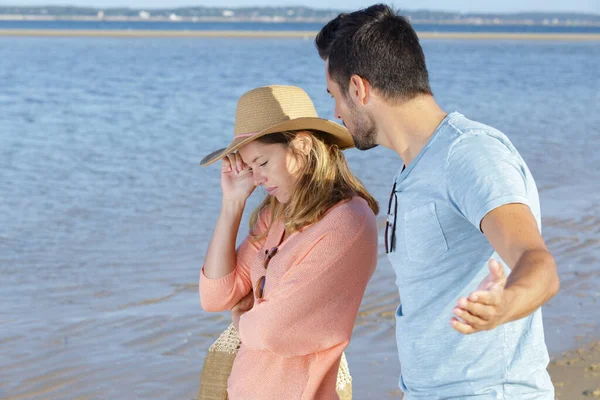 这对心烦意乱的夫妇在海滩上互相望着对方 — 图库照片