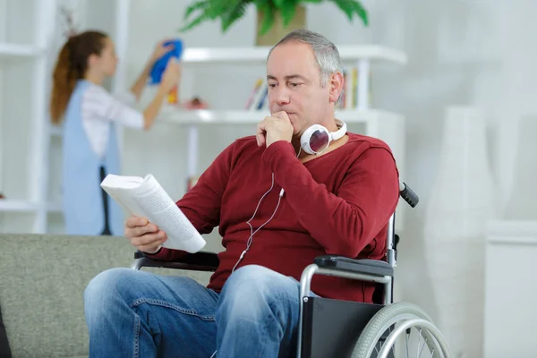 Άνθρωπος Αναπηρική Καρέκλα Διαβάζοντας Ένα Βιβλίο — Φωτογραφία Αρχείου
