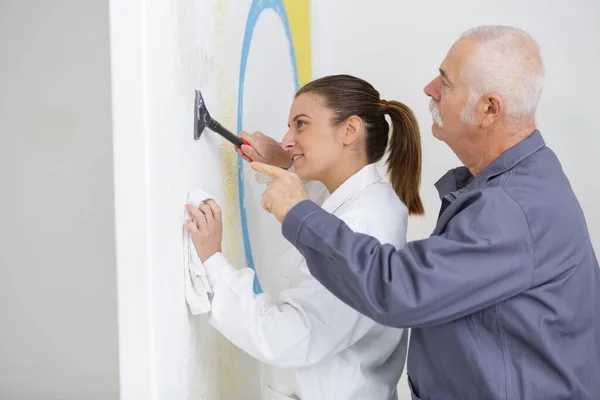 Vorgesetzte Zeigt Dekorations Lehrling Wie Man Wand Kratzt — Stockfoto