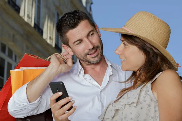 Para Ulicy Torbami Zakupy Patrząc Smartfona — Zdjęcie stockowe