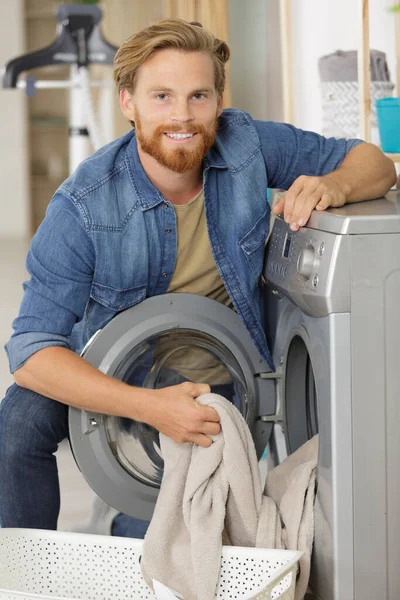 Junger Mann Lädt Kleidung Küche Waschmaschine — Stockfoto