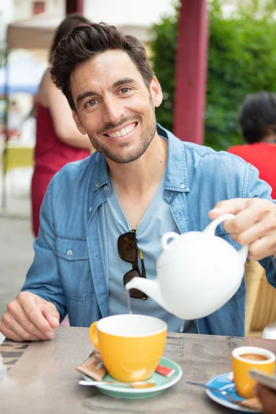 Junger Mann Gießt Tee Restaurant Ein — Stockfoto