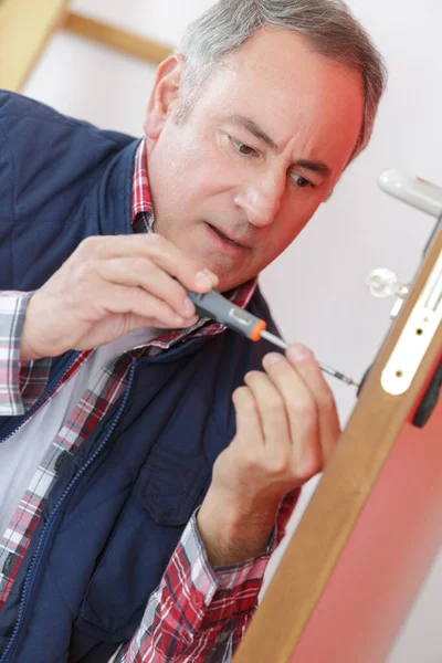 Uomo Anziano Avvitando Serratura Porta — Foto Stock