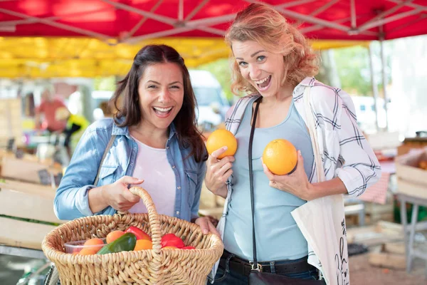 女人们在市场上吃水果时很有趣 — 图库照片
