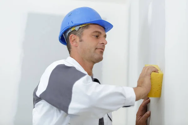 Construtor Masculino Usando Uma Esponja Uma Parede Rebocada — Fotografia de Stock