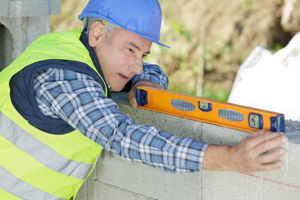 Männliche Bauarbeiter Mit Einer Ebene Der Wand — Stockfoto