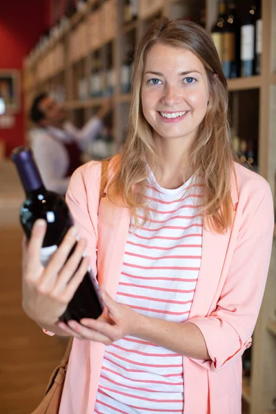 Mulher Segurando Garrafa Vinho Tinto Uma Loja — Fotografia de Stock