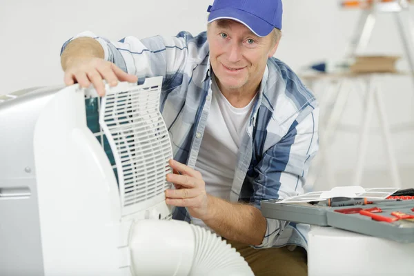 Senior Male Fixing Air Conditioning Filter — Stock Photo, Image