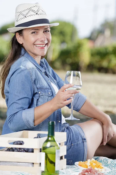 快乐的女人在葡萄园里举着一杯白葡萄酒 — 图库照片