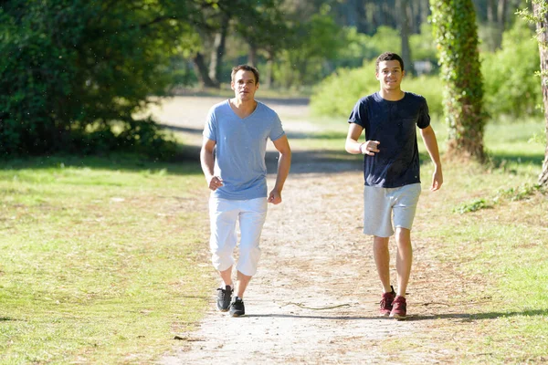 公園を走っている2人の若者が — ストック写真
