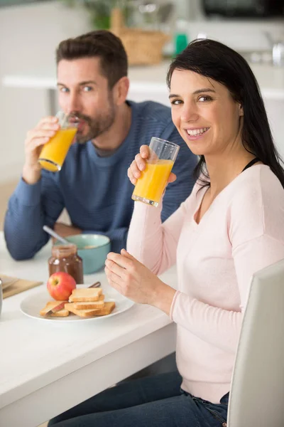 幸せな若いカップルがキッチンで朝食を取り — ストック写真