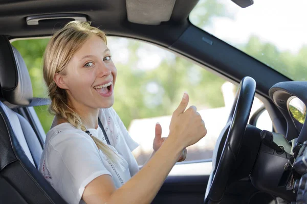 Mujer Conduciendo Coche Mostrando Pulgar Hacia Arriba —  Fotos de Stock